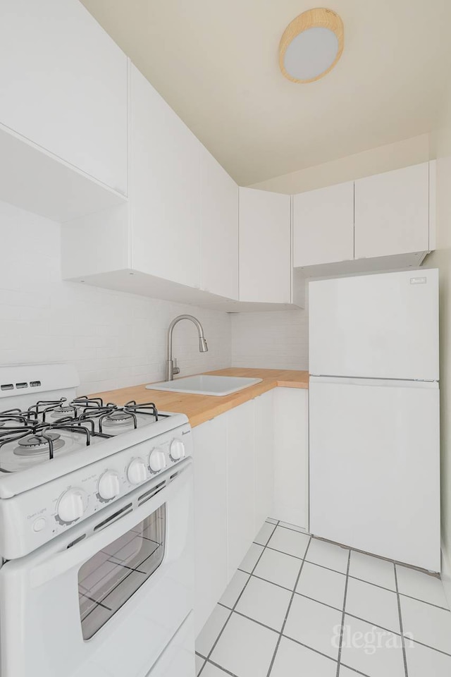 25 W 13th St Unit 6Kn, New York City, NY 10011 - kitchen with white appliances, tasteful backsplash, light countertops, white cabinets, and light tile patterned floors