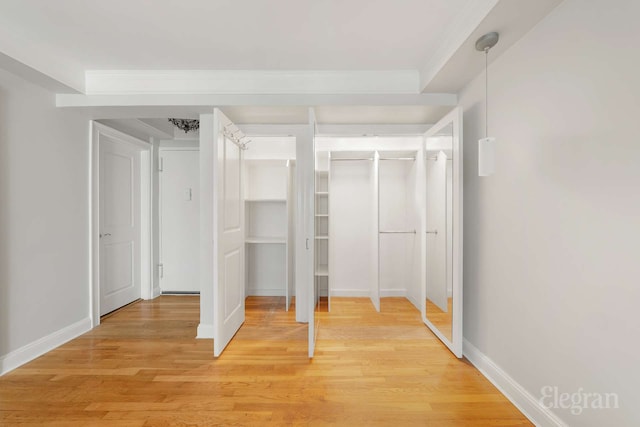 25 W 13th St Unit 6Kn, New York City, NY 10011 - unfurnished bedroom with light wood-style flooring, crown molding, and two closets