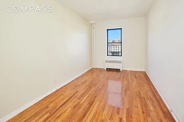 506 W 145th St Unit 4D, New York City, NY 10031 - empty room featuring radiator and light wood-style flooring
