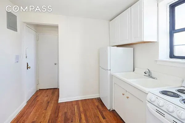506 W 145th St Unit 4D, New York City, NY 10031 - kitchen featuring white appliances, wood finished floors, light countertops, and white cabinets