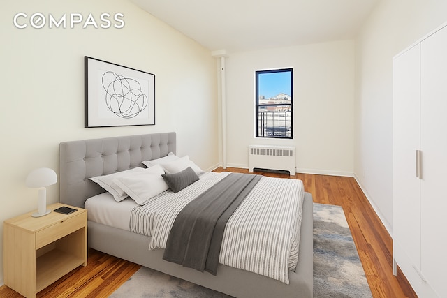 506 W 145th St Unit 4D, New York City, NY 10031 - bedroom with radiator heating unit and wood finished floors