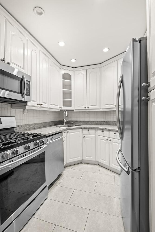 66 Madison Ave Unit 2De, New York City, NY 10016 - kitchen with appliances with stainless steel finishes, white cabinets, light tile patterned flooring, tasteful backsplash, and recessed lighting