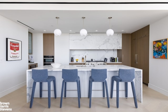 200 Amsterdam Ave Unit 32B, New York City, NY 10023 - kitchen with modern cabinets, stainless steel oven, a spacious island, a kitchen breakfast bar, and recessed lighting