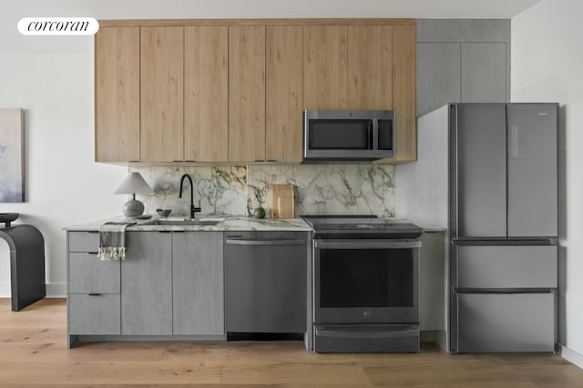 726 Madison St Unit 4A, New York City, NY 11221 - kitchen featuring stainless steel appliances, backsplash, light wood-type flooring, and light stone countertops