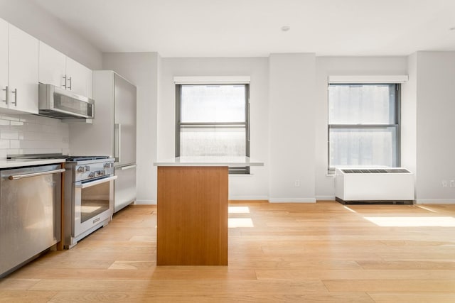 20 W St Unit 18F, New York City, NY 10004 - kitchen featuring high quality appliances, light wood-type flooring, decorative backsplash, and plenty of natural light