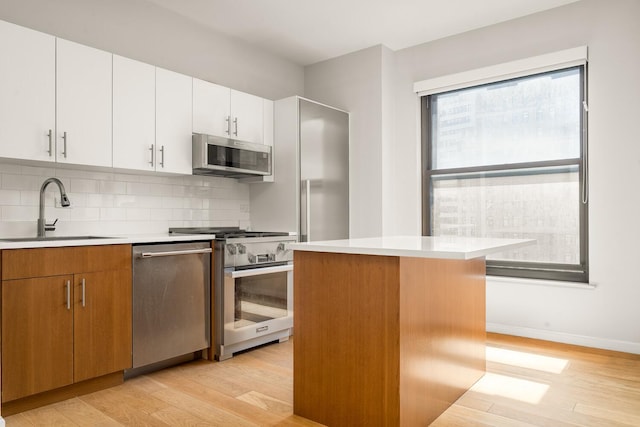 20 W St Unit 18F, New York City, NY 10004 - kitchen featuring appliances with stainless steel finishes, light wood-type flooring, and light countertops