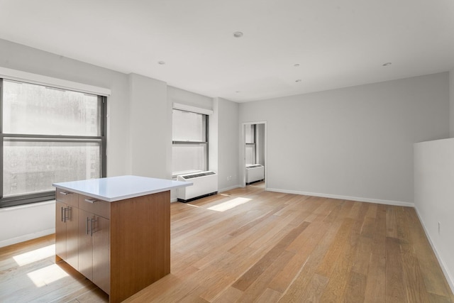 20 W St Unit 18F, New York City, NY 10004 - kitchen with light wood-style flooring, a center island, light countertops, and modern cabinets