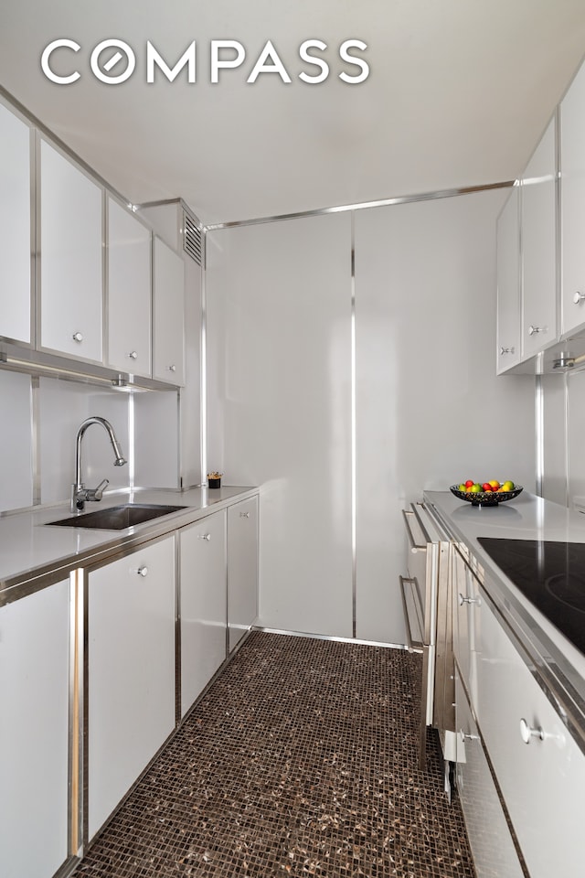 4 E 82nd St Unit 3F, New York City, NY 10028 - kitchen with white cabinets and cooktop