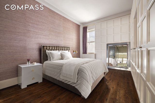 4 E 82nd St Unit 3F, New York City, NY 10028 - bedroom featuring dark wood-type flooring, a fireplace, access to exterior, and wallpapered walls