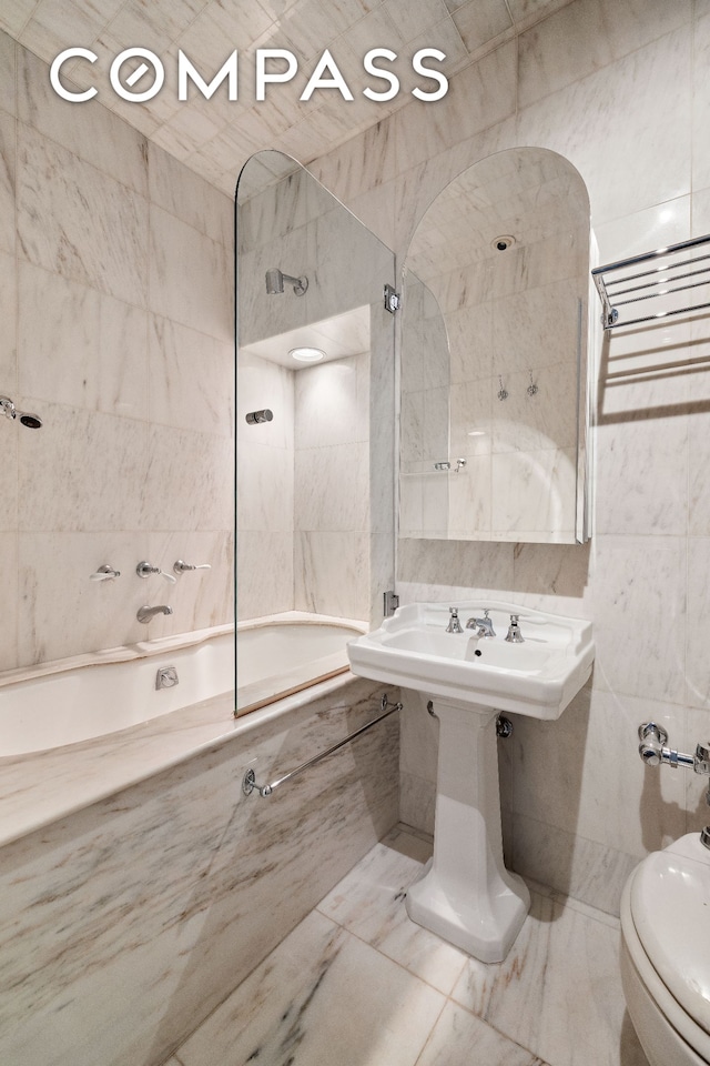 4 E 82nd St Unit 3F, New York City, NY 10028 - full bathroom featuring tile walls, tiled shower / bath, marble finish flooring, and a bidet