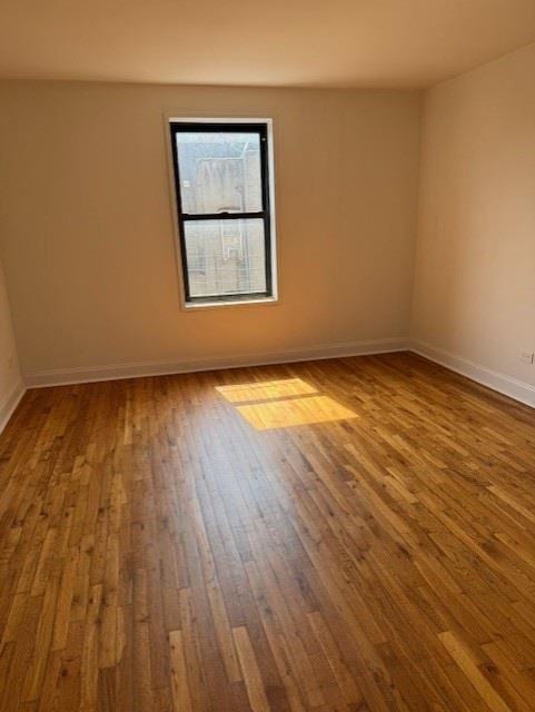 282 E 35th St Unit 4W, New York City, NY 11203 - spare room featuring hardwood / wood-style flooring and baseboards