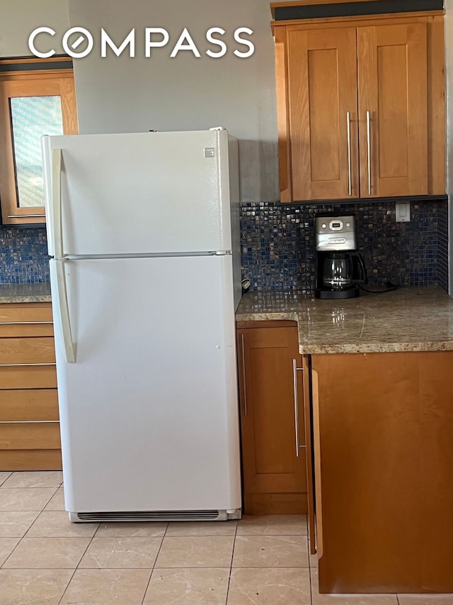 2035 E 7th St Unit 6B, New York City, NY 11223 - kitchen with freestanding refrigerator, light tile patterned flooring, and brown cabinetry