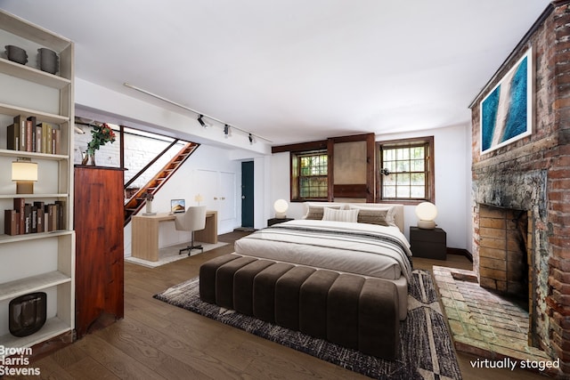 47 King St Unit 2, New York City, NY 10014 - bedroom featuring hardwood / wood-style flooring, track lighting, and a brick fireplace