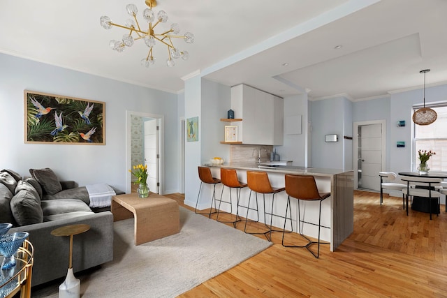 26 Gramercy Park S Unit 8Cd, New York City, NY 10003 - kitchen featuring a kitchen bar, a peninsula, light wood-style floors, crown molding, and tasteful backsplash