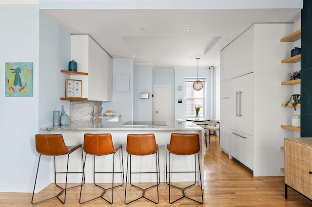 26 Gramercy Park S Unit 8Cd, New York City, NY 10003 - kitchen with open shelves, a peninsula, white cabinets, and a breakfast bar area