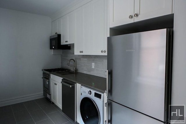 160 E 3rd St Unit 2F, New York City, NY 10009 - kitchen with freestanding refrigerator, washer / dryer, black microwave, dishwashing machine, and dark countertops