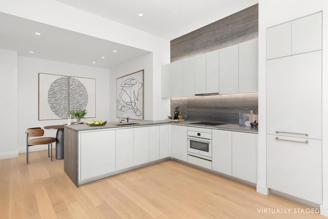 1 Wall St Unit 2413, New York City, NY 10005 - kitchen with oven, modern cabinets, white cabinets, decorative backsplash, and recessed lighting