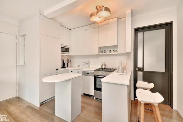 39 W 67th St Unit 1503, New York City, NY 10023 - kitchen featuring stainless steel appliances, light countertops, and light wood-type flooring