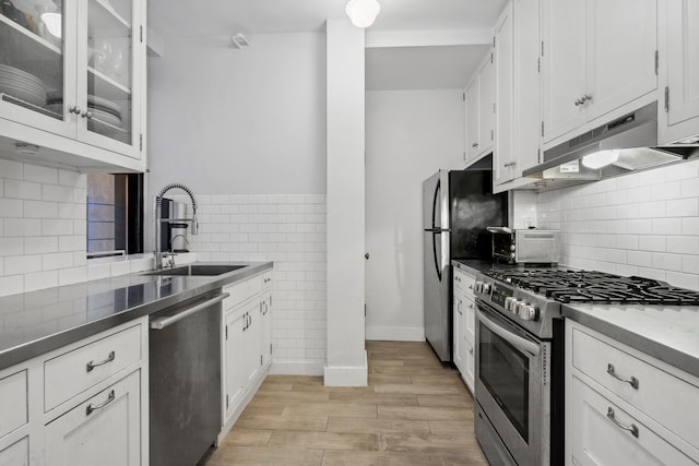 255 W End Ave Unit 4A, New York City, NY 10023 - kitchen with appliances with stainless steel finishes, under cabinet range hood, white cabinets, light wood-type flooring, and glass insert cabinets