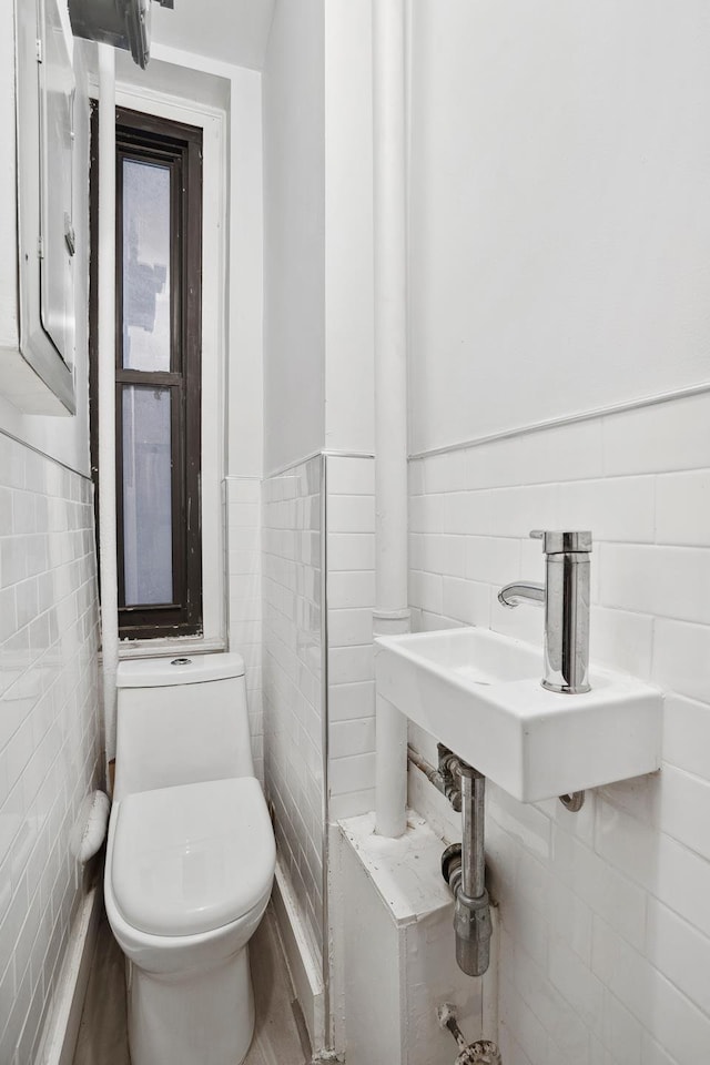 255 W End Ave Unit 4A, New York City, NY 10023 - half bathroom featuring tile walls and a wainscoted wall