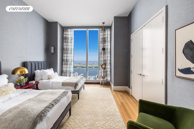 217 W 57th St Unit 84W, New York City, NY 10019 - bedroom featuring light wood-style flooring and a water view