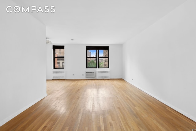 229 E 28th St Unit 6D, New York City, NY 10016 - unfurnished room featuring radiator, light wood finished floors, and an AC wall unit