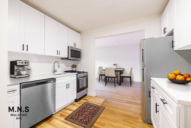 84-55 Daniels St Unit 3-H, New York City, NY 11435 - kitchen with appliances with stainless steel finishes, light countertops, light wood-type flooring, and white cabinetry