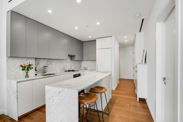 287 E Houston St Unit 4B, New York City, NY 10002 - kitchen with gray cabinets, modern cabinets, a kitchen island, and recessed lighting