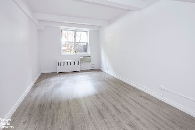 345 E 54th St Unit C, New York City, NY 10022 - unfurnished room featuring radiator, beam ceiling, wood finished floors, and a wall mounted air conditioner