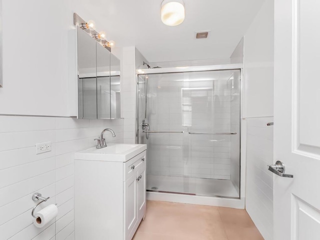 301 W 118th St Unit 7-H, New York City, NY 10026 - bathroom featuring a stall shower, vanity, tile walls, and tile patterned flooring