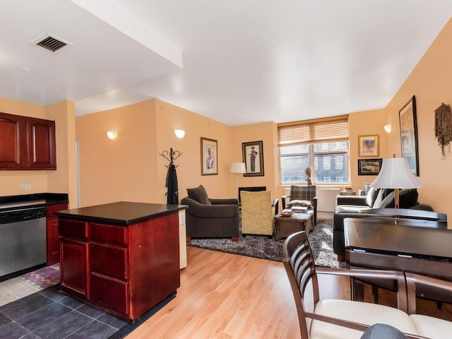 301 W 118th St Unit 7-H, New York City, NY 10026 - kitchen with stainless steel dishwasher, reddish brown cabinets, open floor plan, dark countertops, and wood finished floors