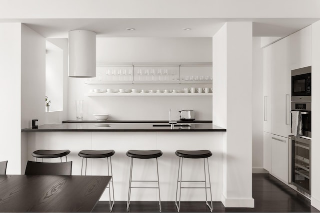 923 5th Ave Unit 12E/11, New York City, NY 10021 - kitchen with built in microwave, a breakfast bar area, beverage cooler, and oven