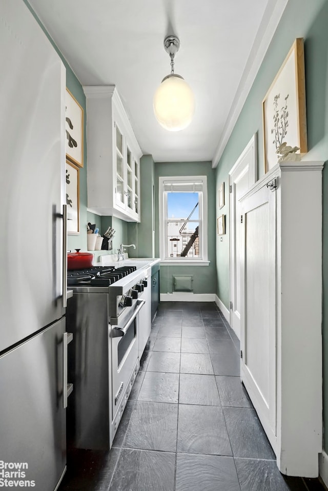 242 E 19th St Unit 13E, New York City, NY 10003 - kitchen with freestanding refrigerator, designer range, white cabinetry, glass insert cabinets, and pendant lighting