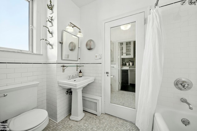 242 E 19th St Unit 13E, New York City, NY 10003 - full bathroom featuring shower / bath combo, tile patterned flooring, tile walls, and wainscoting