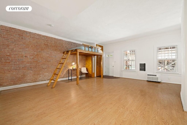 280 W 12th St Unit 1W, New York City, NY 10014 - unfurnished living room with wood finished floors, a wall unit AC, and brick wall