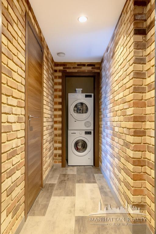 3567 Shore Pkwy Unit 4A, New York City, NY 11235 - laundry area with brick wall and estacked washer and dryer