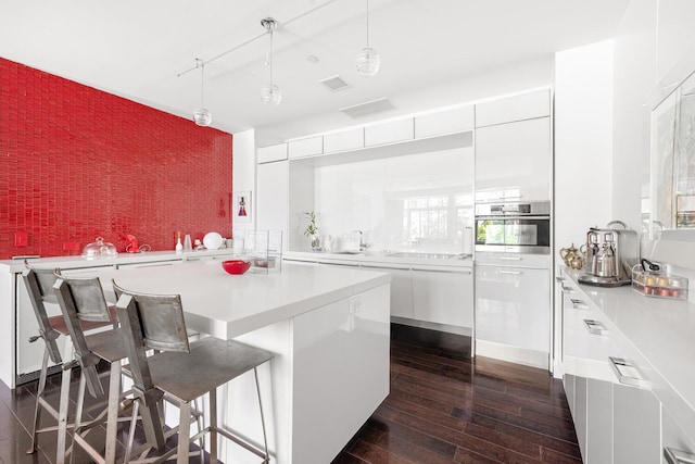 111 Fulton St Unit Ph111, New York City, NY 10038 - kitchen with an accent wall, dark wood finished floors, modern cabinets, white cabinetry, and light countertops