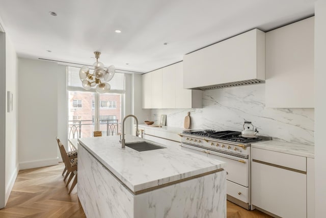 1228 Madison Ave Unit 4, New York City, NY 10128 - kitchen with double oven range, a chandelier, white cabinets, decorative backsplash, and a center island with sink