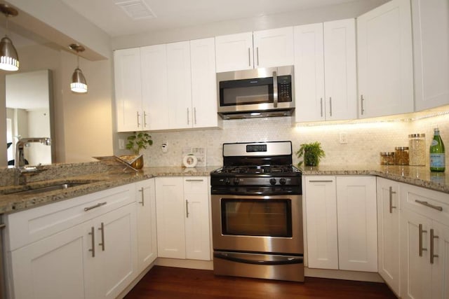 603 W 148th St Unit 3, New York City, NY 10031 - kitchen featuring stainless steel appliances, white cabinetry, dark wood-style flooring, and decorative backsplash