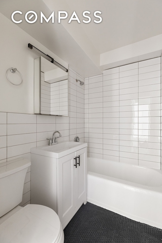 411 E 53rd St Unit 6L, New York City, NY 10022 - bathroom featuring vanity, shower / tub combination, tile walls, and tile patterned flooring
