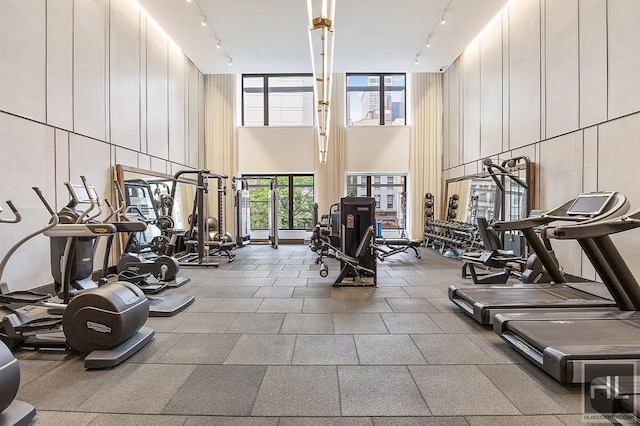 301 E 50th St Unit 5B, New York City, NY 10022 - workout area featuring track lighting, a towering ceiling, and a decorative wall
