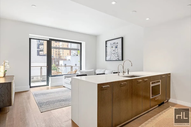 301 E 50th St Unit 5B, New York City, NY 10022 - kitchen featuring oven, light wood-style floors, light countertops, open floor plan, and a peninsula