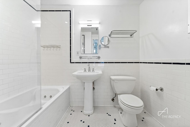 422 State St Unit 6, New York City, NY 11217 - bathroom featuring tile patterned floors, tile walls, tiled shower / bath, and a wainscoted wall