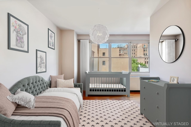 251 E 32nd St Unit 8H, New York City, NY 10016 - bedroom with wood finished floors and a chandelier