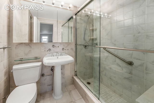 50 Sutton Pl S Unit 5E, New York City, NY 10022 - bathroom featuring tile walls, a stall shower, and tile patterned floors