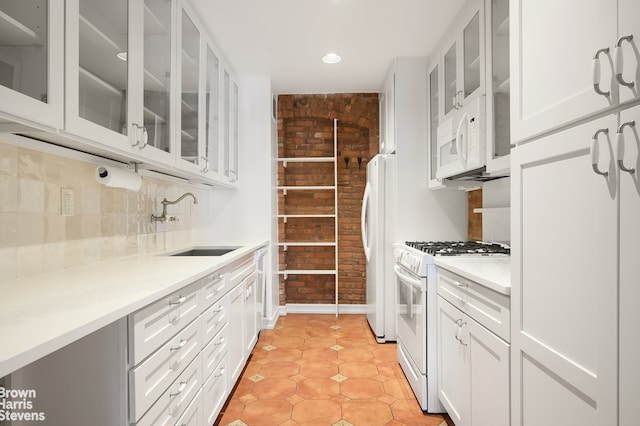 380 W 12th St Unit 6B, New York City, NY 10014 - kitchen featuring white appliances, brick wall, glass insert cabinets, white cabinets, and light countertops