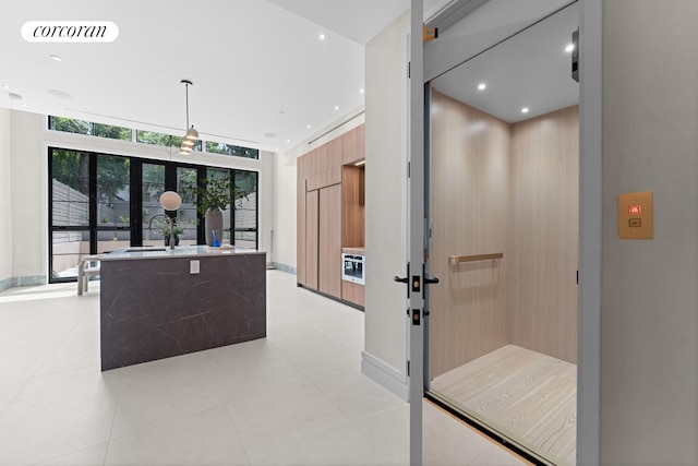966 Bergen St, New York City, NY 11216 - kitchen featuring modern cabinets, elevator, french doors, light countertops, and a kitchen island with sink