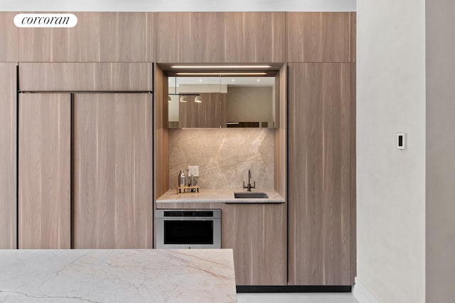 966 Bergen St, New York City, NY 11216 - kitchen with modern cabinets, stainless steel oven, decorative backsplash, and light stone countertops