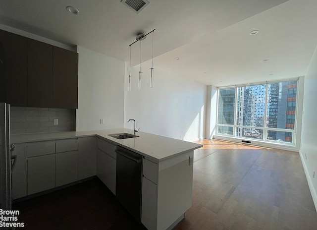 27-17 42nd Rd Unit 14G, New York City, NY 11101 - kitchen featuring dishwasher, a peninsula, dark wood-style flooring, decorative backsplash, and open floor plan