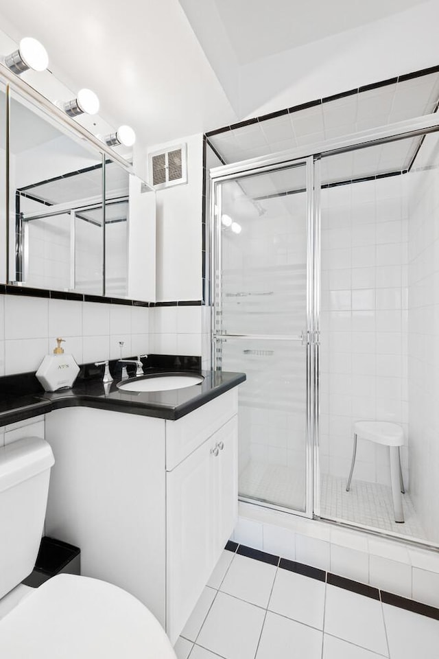 239 E 79th St Unit 9A, New York City, NY 10075 - bathroom with vanity, a shower stall, tile patterned floors, and backsplash